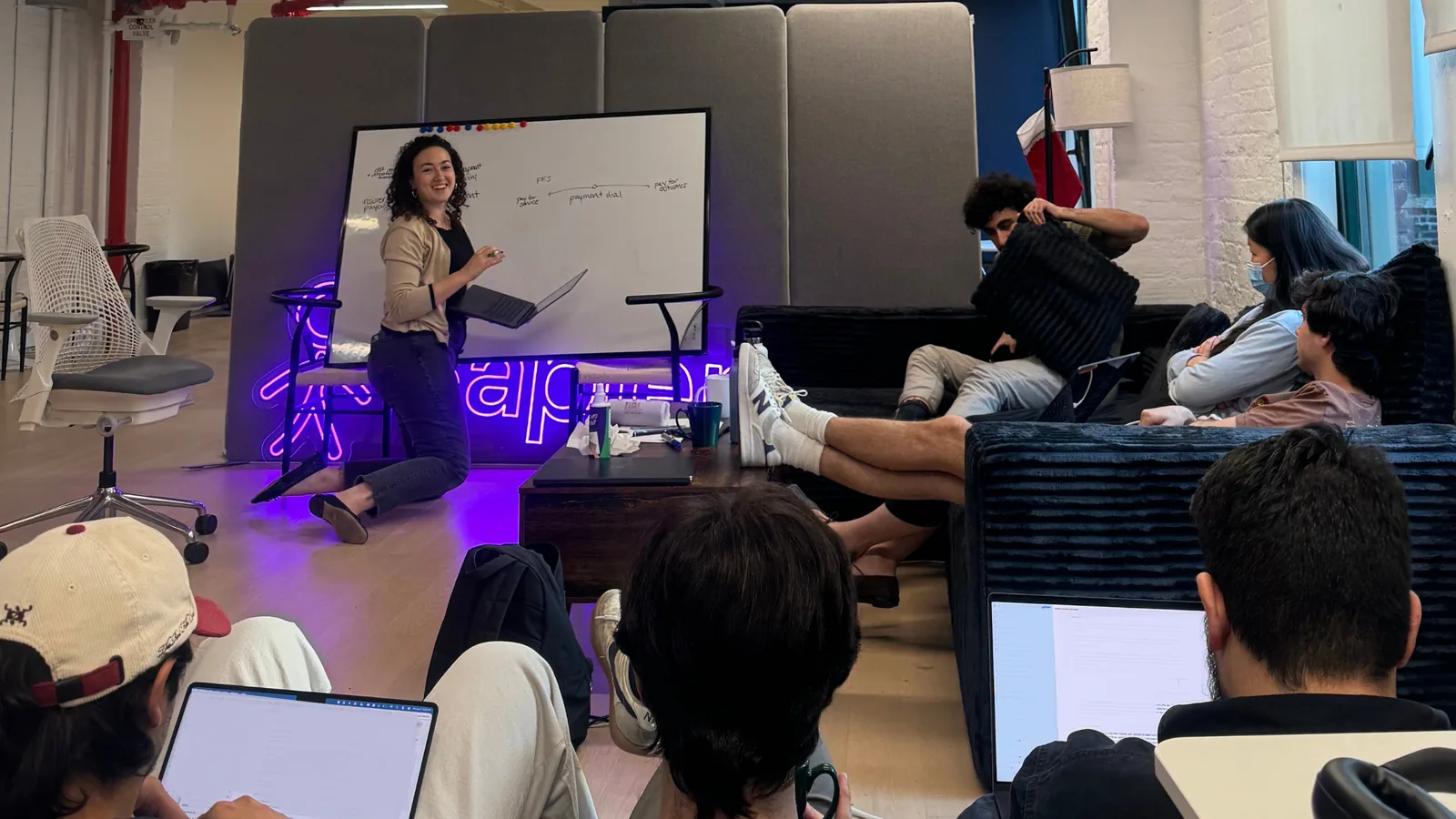 Sapien teammates in a team talk around the whiteboard