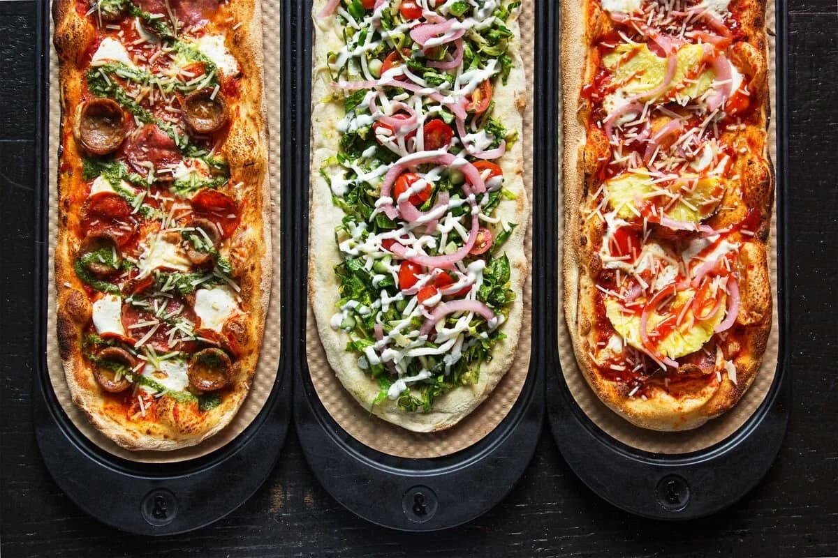 Three &pizza pies with a variety of toppings
