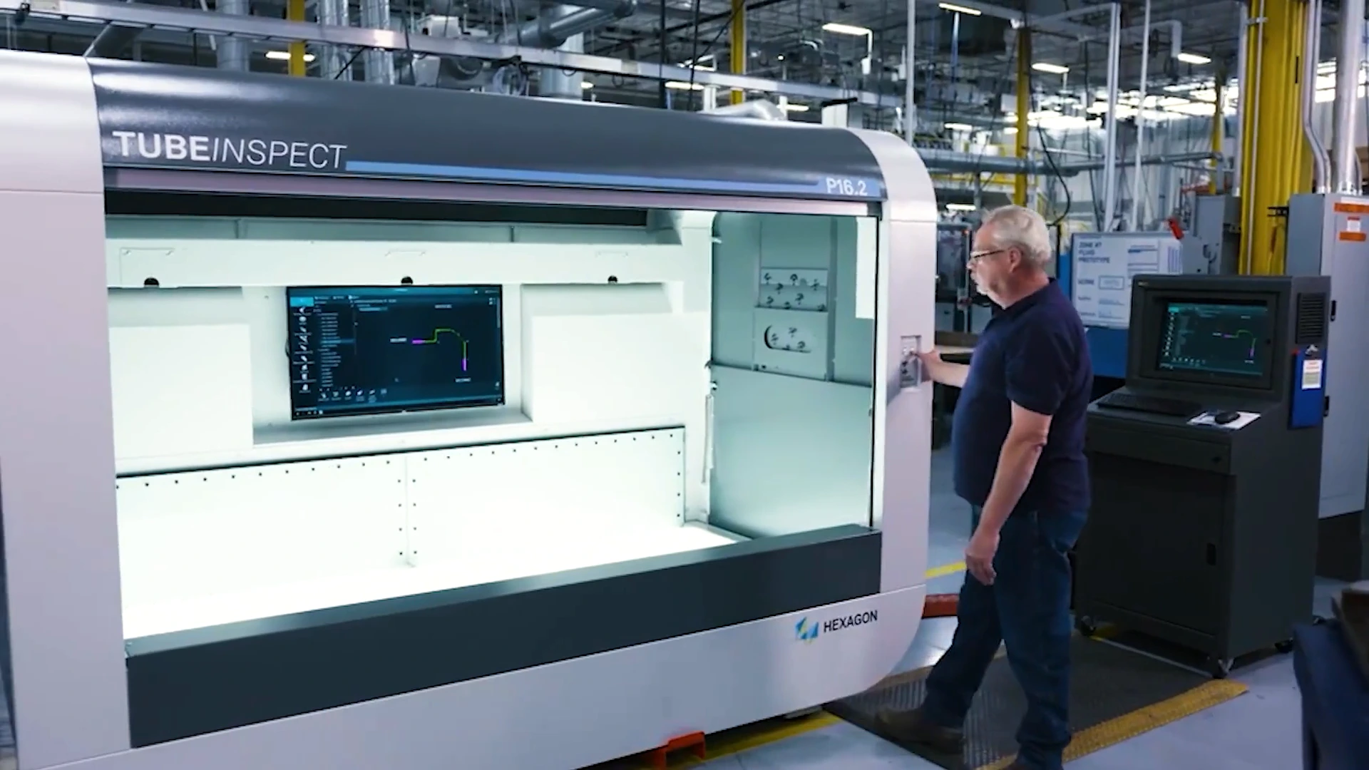 A Cooper Standard employee operating a tube-inspection machine on the factory floor